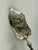 Intricately hand-engraved figural and floral motifs adorn the asymmetrical blade of this server which is mounted on a...