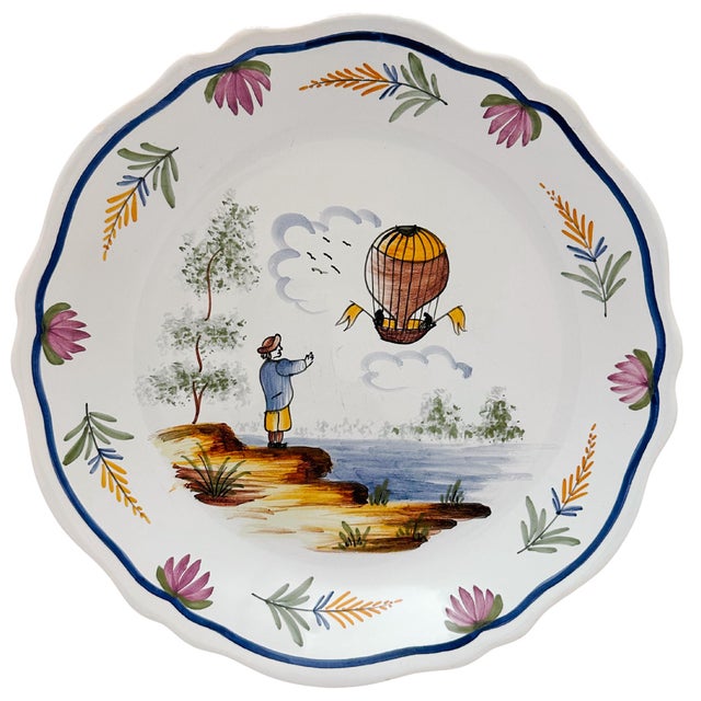 A set of three hand-painted faience plates from France, featuring unique hot air balloon designs. Each plate is handmade...