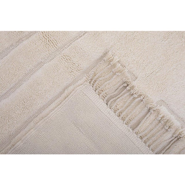 Refined hand-knotted wool rug in Pearled Ivory, featuring a linear textured pattern with balanced symmetry. Its subtle...