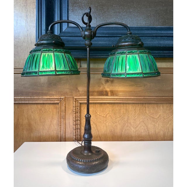 A Linenfold Favrile glass double student lamp from Tiffany Studio (1878-1933) circa 1910s. This rare model features two...