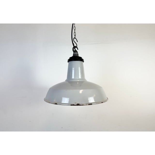 Industrial grey enamel factory pendant light made in United Kingdom during the 1960s. White enamel inside the shade....
