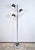 Chromed metal floor lamp with three arms of light. The lampshades are rotating to modulate the light sources. The tubular...