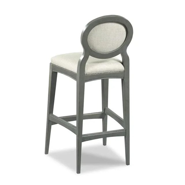 A sleek design with graceful tapered legs that are joined by low stretchers and curved apron rails. The stool features an...