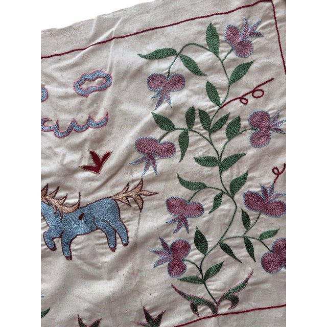 Hand-embroidered Suzani panel from Uzbekistan, worked in fine floss on a cream cotton ground. Two winged horses and two...