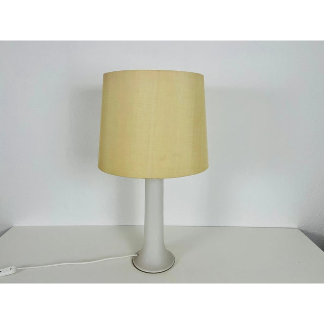A beautiful large table lamp made in the 1960s by luxus sweden. The base is made of white glass. The lamp shade is made of...