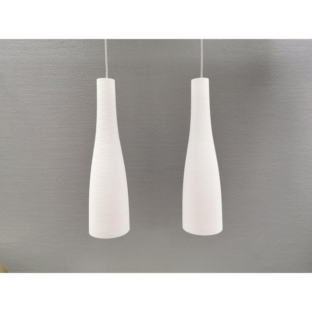 Pendants/hanging lamps in handmade/mouth-blown white murano glass with hand-cut grooves that wind around the glass surface...