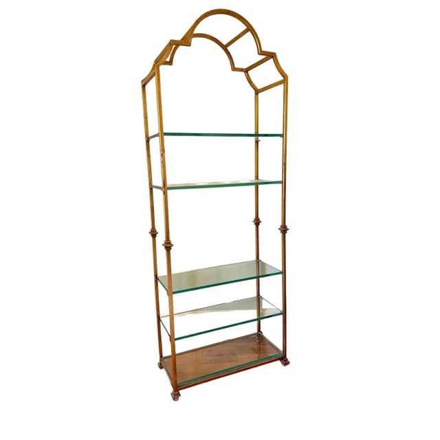 A mid century Italian Neoclassical heavy gilt iron etagere with five glass shelves. Product Information: Materials: Iron,...