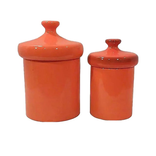 Mid-Century orange canisters in ceramic with a slightly speckled finish. The vintage canisters are a large size and in...