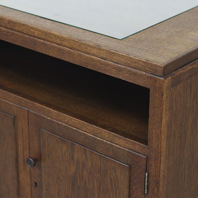 Art Deco bar cabinet with a sleek design, crafted from solid oak and oak veneer. The top features an inlaid glass panel,...