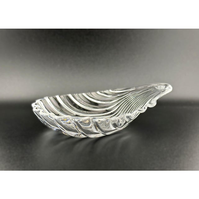 A heavy lead crystal shell dish in the "Coquille" pattern by Baccarat. Known for its brilliant clarity and deep fluting,...