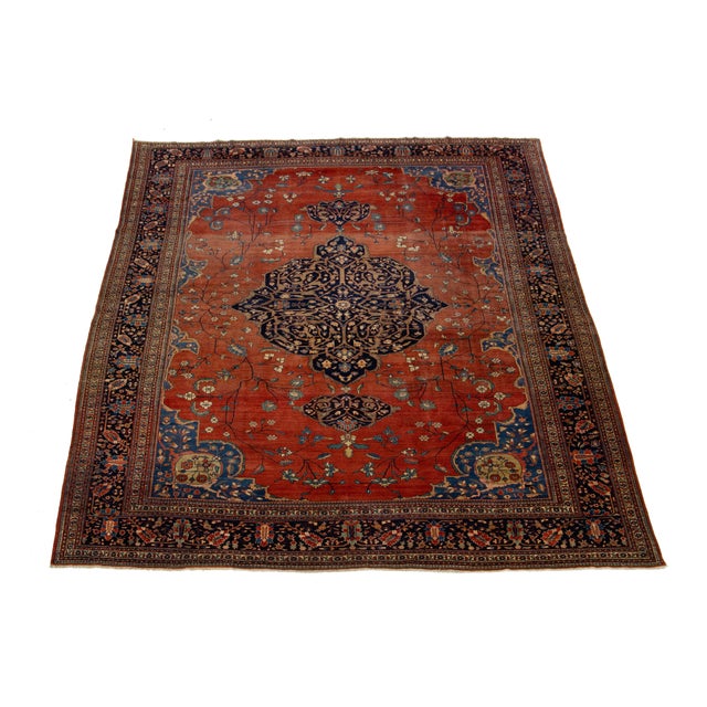 This beautiful antique Persian Farahan hand-knotted wool rug dates back to the 1880s. Its red-rust field features classic...