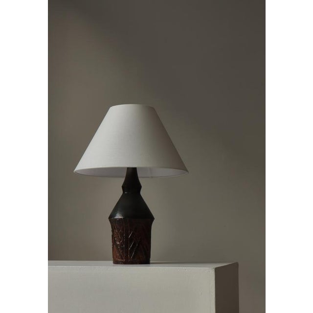 A striking example of mid-century Scandinavian craftsmanship, this 1960s hand-thrown stoneware table lamp by Sejer Denmark...