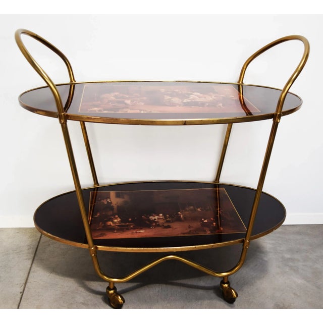 This Italian vintage bar trolley or cart is from the 1960s. It has a brass structure with polyester lacquered wooden...