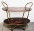 This Italian vintage bar trolley or cart is from the 1960s. It has a brass structure with polyester lacquered wooden...