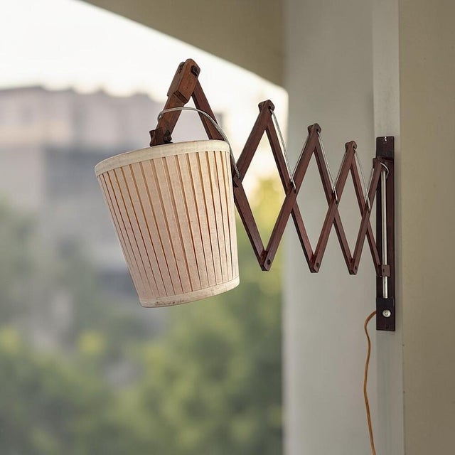 Vintage wooden scissor wall lamp featuring an adjustable accordion-style extension arm. The articulated wooden mechanism...