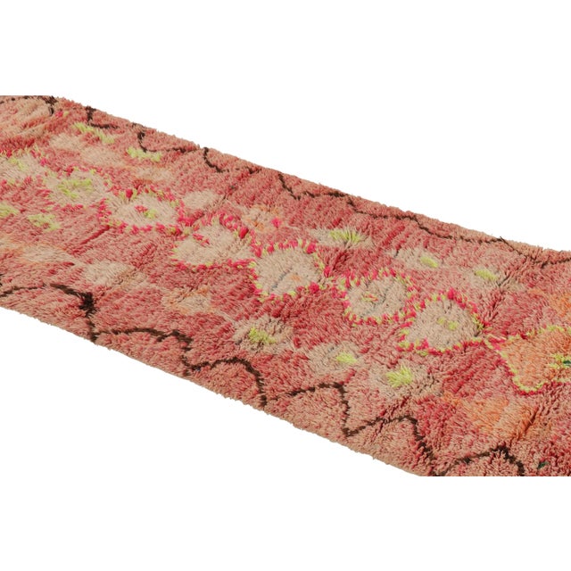 Hand-knotted in wool and originating from Morocco circa 1950-1960, this 3x8 vintage runner rug is a rare and among the...