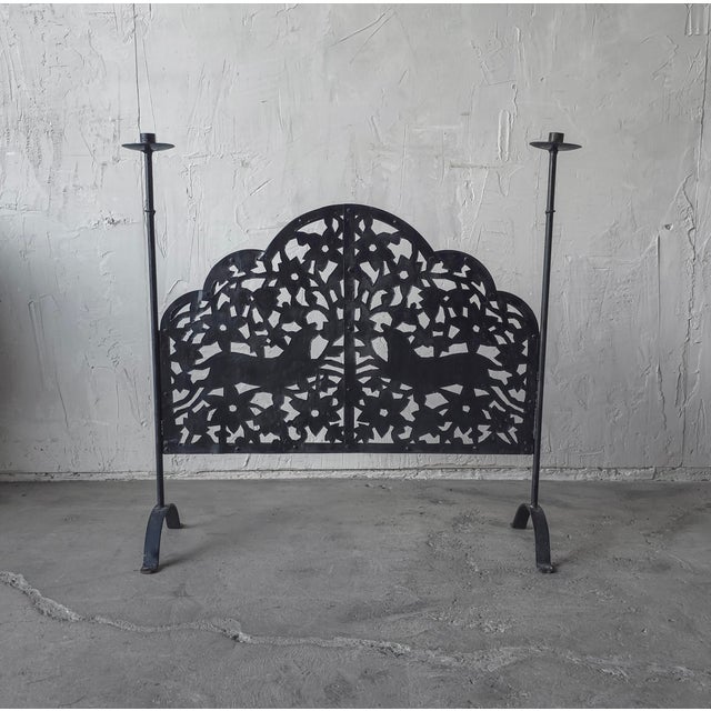 This is vintage wrought iron fireplace screen featuring hand pierced floral decoration and a pair of stylized deer. The...
