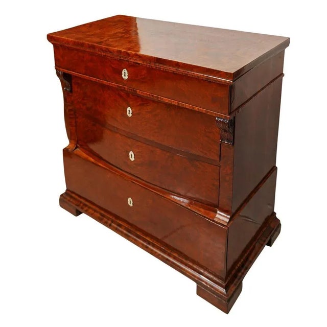 Biedermeier Walnut and Mother-of-Pearl Chest of Drawers crafted in walnut veneer with mother-of pearl keyhole escutcheons....