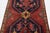 This hand-knotted wool rug has a navy blue and red field with multicolor accents all over the design. This rug measures...
