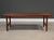 A mid century modern tall teak coffee table with simple lines and side stretchers. Unmarked. Made in Denmark....
