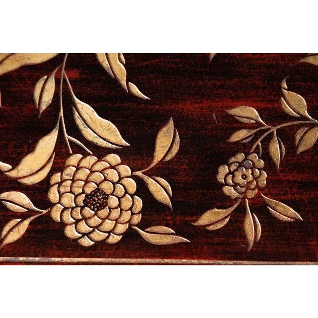 A Chinese vintage lacquered coffee table from the mid-20th century, with carved gilt floral motifs. Born in China during...