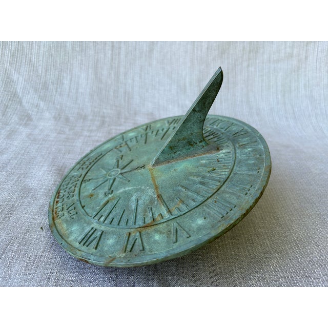 Vintage bronze verde sundial with Roman numerals, a compass and "Time Takes All But Memories" written along the bottom...