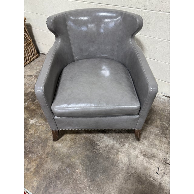 Amazing grey leather club chair with nailhead detail. Leather has a gloss finish. Ironies produces some of the highest...
