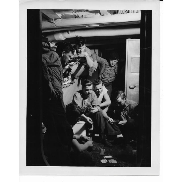 1952 US Navy black & white photo of sailors playing cards and gambling in their quarters. Publication information on the...
