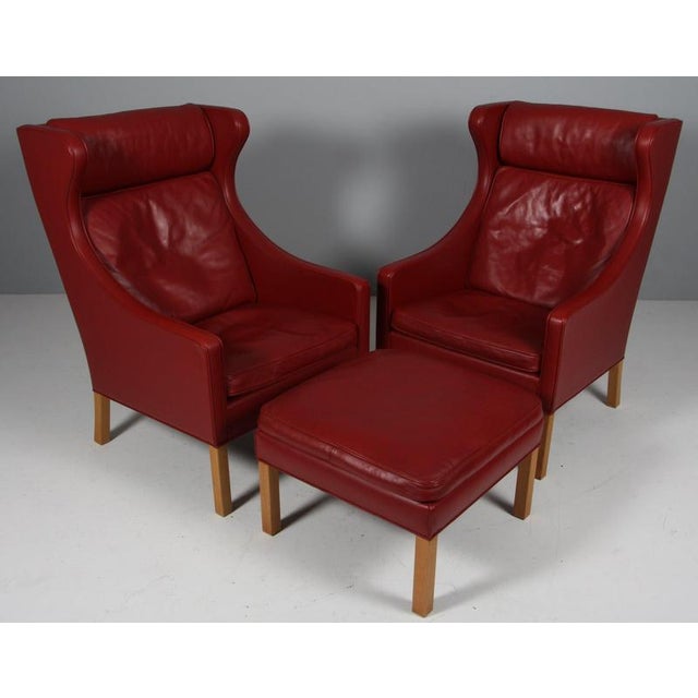 Børge Mogensen wingback chairs and ottoman original upholstered with red leather. Legs of oak. Model 2202 and 2204, made...