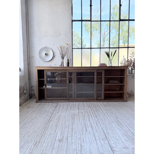 A vintage 1950s pine sideboard with solid oak sliding glass doors. we love the elegance of this piece, with its unique and...