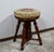 Piano stool in solid walnut, adjustable in height, is dressed in an original canvas, studded on braid and in perfect...