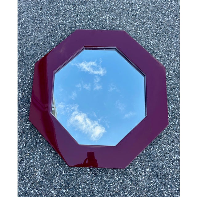 This octagonal mirror boasts a bold geometric design typical of the Hollywood Regency aesthetic. Its beveled edge is...