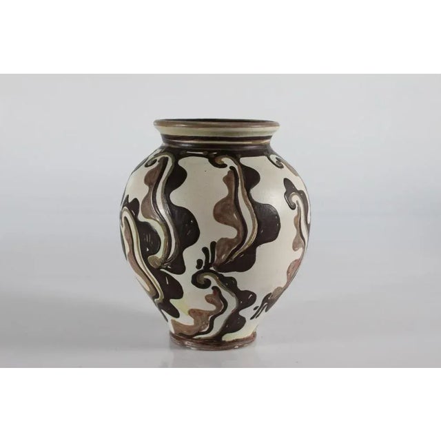Danish ceramic handmade vase by Herman A. Kähler. The vase has a matte sand colored basecoat with abstract hand-decorated...