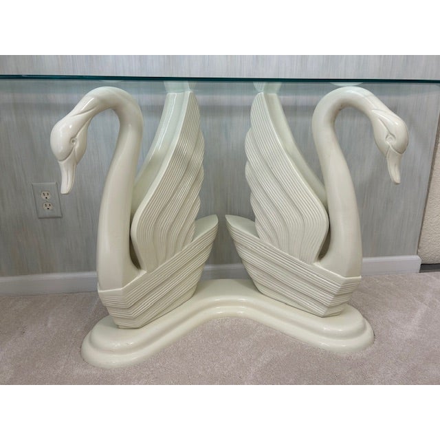 The base is composed of two sculpted swan figures, made of carved wood with an ivory enamel finish, positioned...