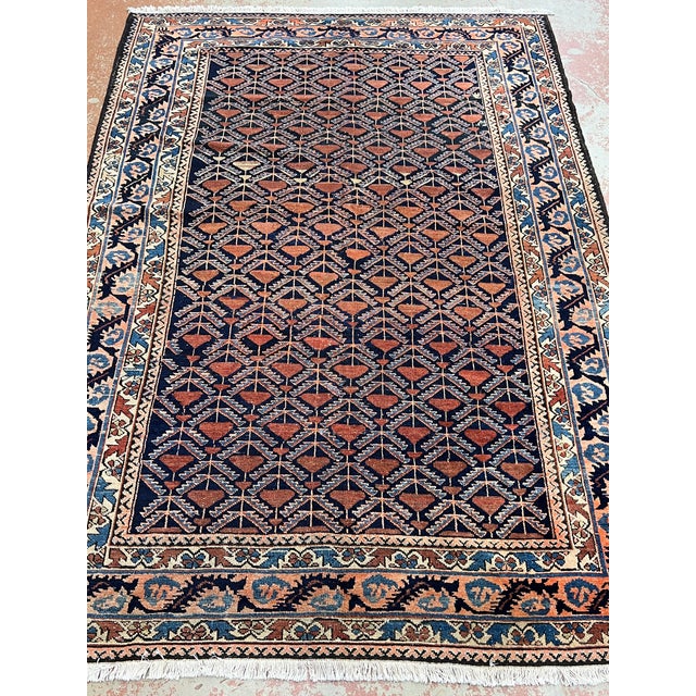 Antique Persian rug, hand-knotted in Iran from 100% wool. Measuring 4’9” x 6’8”, the rug features a striking all-over...