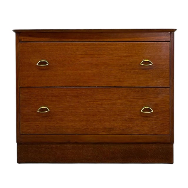 Vintage mid-century modern two-drawer chest featuring clean lines and warm veneer construction. This piece exemplifies the...