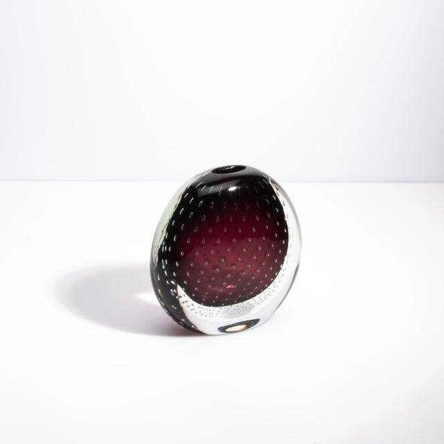 This exquisite hand-blown Murano vase, rendered in a deep amethyst hue, is a true masterpiece that showcases the...