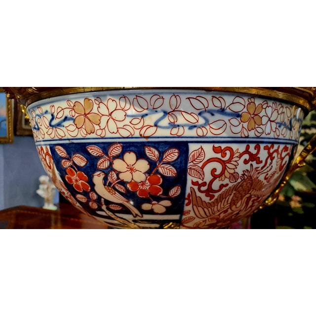 Large and important porcelain bowl painted with floral representations in cobalt blue below deck, brick and gold above...
