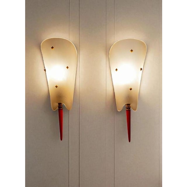 Pair of vintage wall sconces, authentic to the mid-20th century. Each sconce stands out with its textured white shade with...