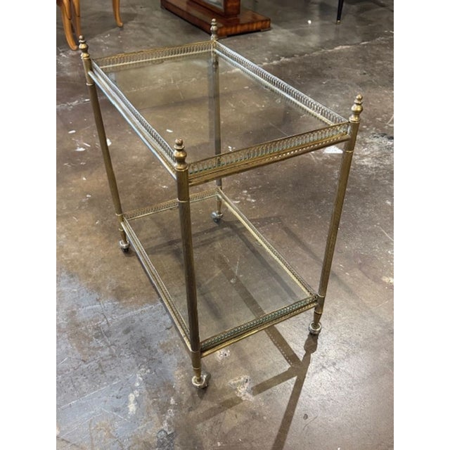 The Mid Century French Brass Serving Cart is a stylish and modern piece of furniture designed for serving drinks and...