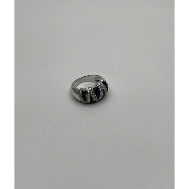 Crafted this exquisite piece features a bold design with alternating rows of deep blue sapphires and sparkling diamonds....