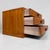 An elegant small Japanese desktop chest with three drawers, warm honey-coloured wood tones and subtle black metal...
