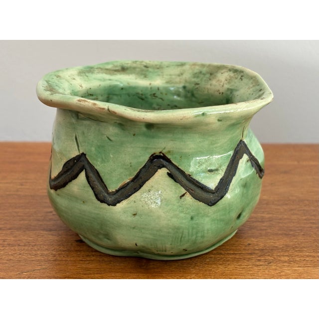 Small folk art pottery planter in a pretty light green trimmed by a dark green scalloped lined. Perfect for holding a...