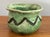 Small folk art pottery planter in a pretty light green trimmed by a dark green scalloped lined. Perfect for holding a...