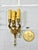 Eye-catching Empire-style three-light wall sconce in gilt brass, featuring a finely detailed spread-winged bird body and...