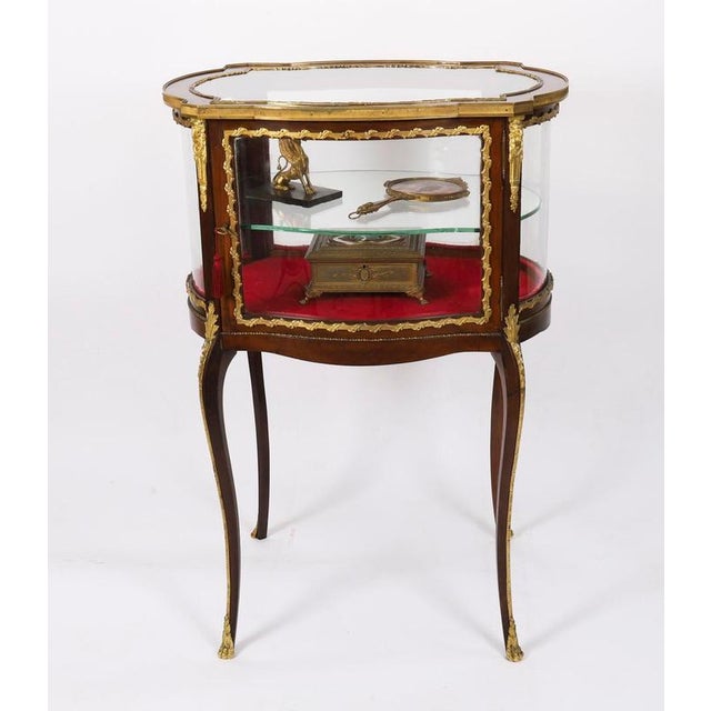 This is a beautiful antique French ormolu mounted walnut bijouterie cabinet, circa 1880 in date. The shaped oval top has a...
