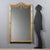 Freestanding mirror made of wood and pastiglia. The grissinata molding is enriched with Neoclassical details, with floral...