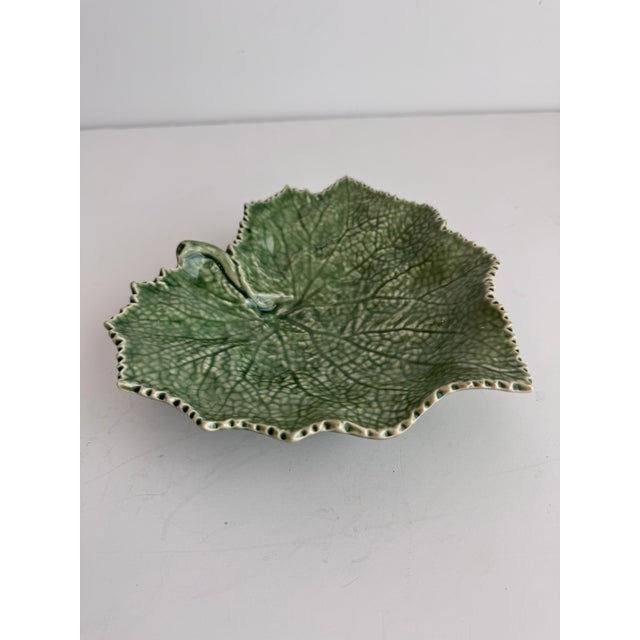 A nice decorative serving piece for fans of Bordallo Pinheiro. This plate sits atop a footed base.