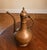 Substantial antique Turkish hand-hammered brass ewer with a graceful elongated spout, hinged domed lid, and curved handle....
