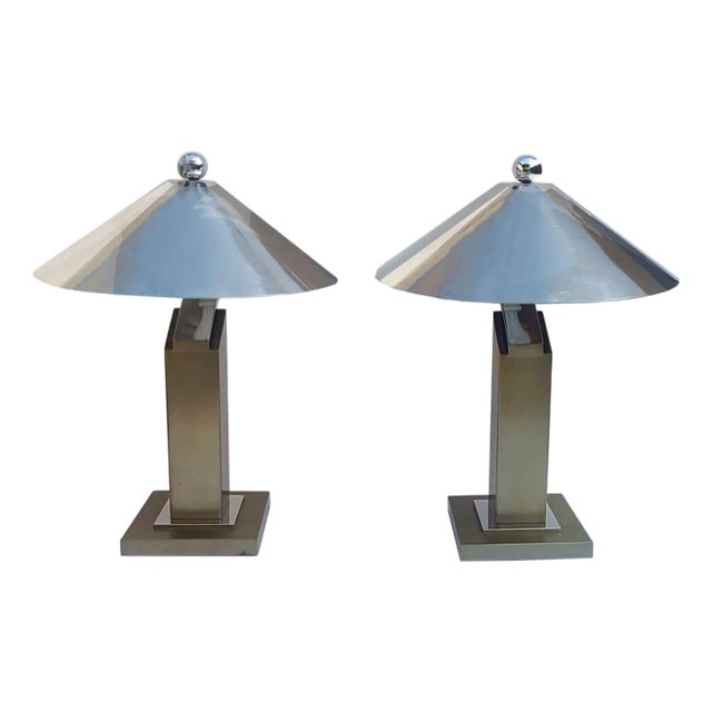 A satin bronze finish washes over cantilevered columns and bases. This pair of monumental table lamps are made of steel;...